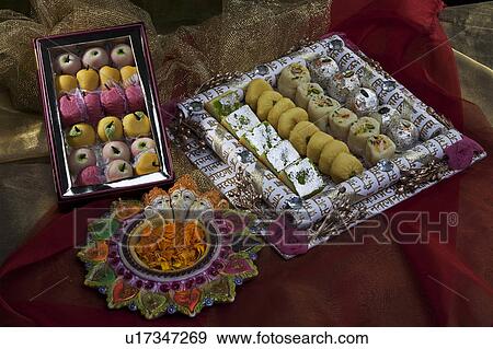 Sweet dishes with unlit diyas View Large Photo Image Stock Photo - Sweet dishes with unlit diyas. Fotosearch