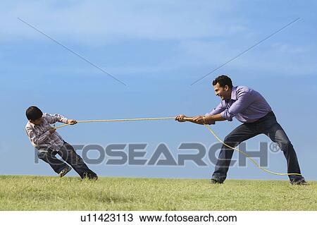 Stock Image - Tug of war between son and father. Fotosearch