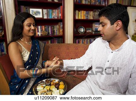 Stock Photo - Tying rakhi on Rakhshabandhan. Fotosearch