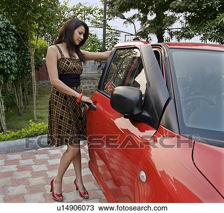 Stock Image - Woman getting into a car. Fotosearch