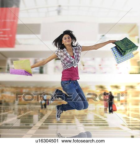 Stock Image - Woman jumping in the air. Fotosearch