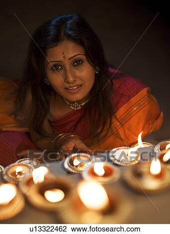 Stock Image - Woman with diyas on Diwali. Fotosearch