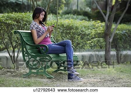 Young Woman looking at her mobile View Large Photo Image Stock Image - Young Woman looking at her mobile. Fotosearch