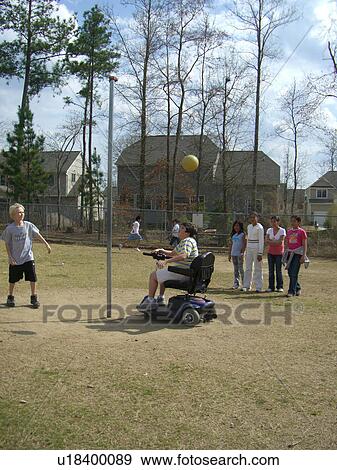 Stock Photo - A boy, who uses a wheelchair, plays tether ball with some friends at recess.. Fotosearch