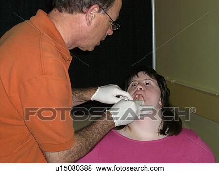Stock Photo - A girl gets her teeth checked.. Fotosearch