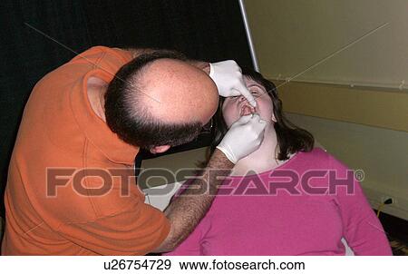 Stock Photo - A girl gets her teeth checked.. Fotosearch
