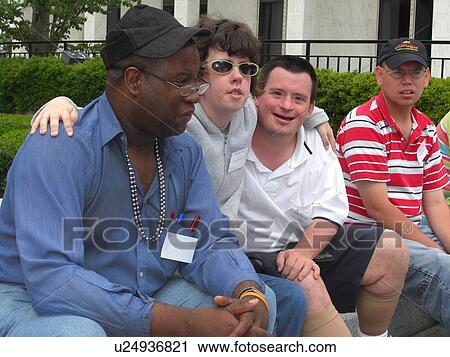 Stock Image - A group of friends enjoy a hello after a long time being apart.. Fotosearch