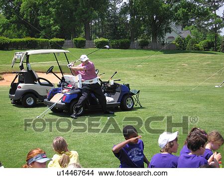 A man displays how he plays golf to a group of fans. View Large Photo Image Picture - A man displays how he plays golf to a group of fans.. Fotosearch
