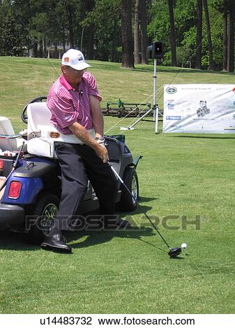 Stock Image - A man displays how he plays golf to a group of fans.. Fotosearch