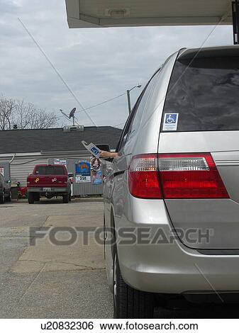 Stock Photograph - A woman holds a handicap parking permit.. Fotosearch