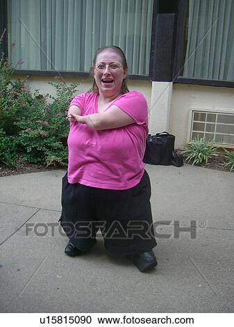 Stock Image - A woman, who is of short stature, enjoys a cigarette.. Fotosearch