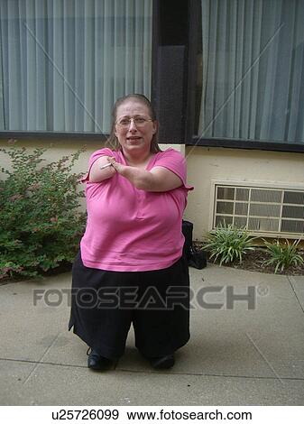 Stock Photo - A woman, who is of short stature, enjoys a cigarette.. Fotosearch
