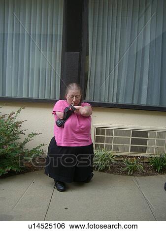 Stock Photograph - A woman, who is of short stature, enjoys a cigarette.. Fotosearch