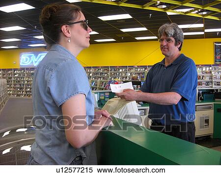 Stock Photography - A woman, who is visually impaired, pays for her food after eating at her favorite restaurant.. Fotosearch