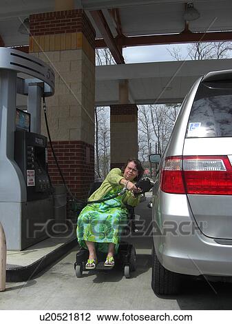 A woman, who uses a wheelchair, fills her car up with gas. View Large Photo Image Stock Image - A woman, who uses a wheelchair, fills her car up with gas.. Fotosearch