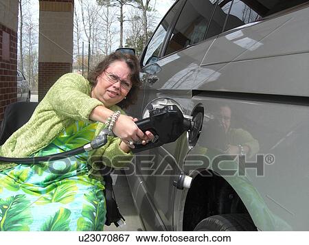 A woman, who uses a wheelchair, fills her car up with gas. View Large Photo Image Stock Photo - A woman, who uses a wheelchair, fills her car up with gas.. Fotosearch