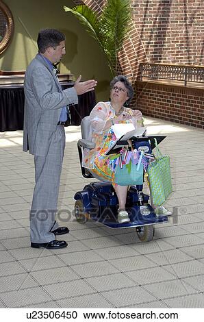 A woman, who uses a wheelchair, prepares for a meeting. View Large Photo Image Stock Image - A woman, who uses a wheelchair, prepares for a meeting.. Fotosearch
