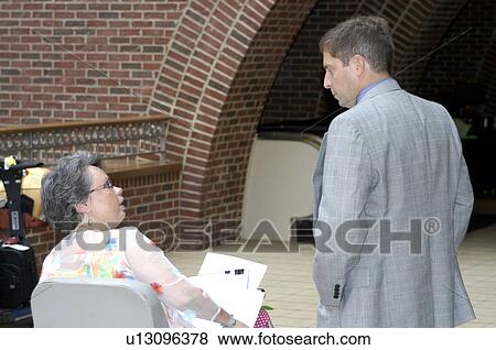 Stock Photo - A woman, who uses a wheelchair, prepares for a meeting.. Fotosearch
