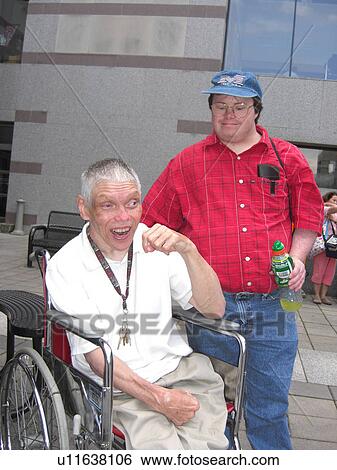 Two friends, one who uses a wheelchair, hang out at a rally. View Large Photo Image Stock Photograph - Two friends, one who uses a wheelchair, hang out at a rally.. Fotosearch