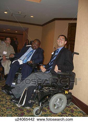 Stock Image - Two men prepare for a business conference.. Fotosearch