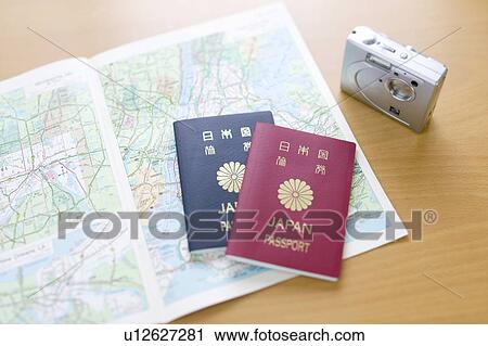 Stock Image - A map, two Japanese passports and a digital camera. Fotosearch