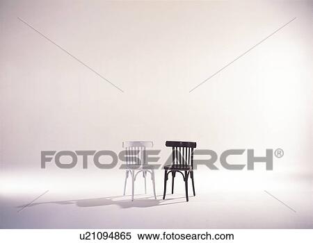 Stock Photography - Black and white wooden chairs side by side. Fotosearch
