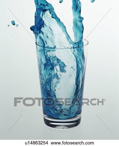 Picture - Blue liquid falling into drinking glass. Fotosearch