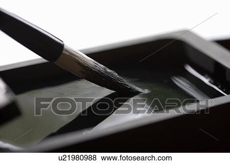 Stock Photo - Calligraphy brush dipping in ink. Fotosearch