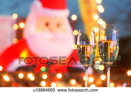 Champagne glasses toasting Christmas in front of Christmas decorations View Large Photo Image Stock Image - Champagne glasses toasting Christmas in front of Christmas decorations. Fotosearch