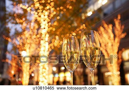 Stock Photography - Champagne glasses toasting Christmas on city street. Fotosearch