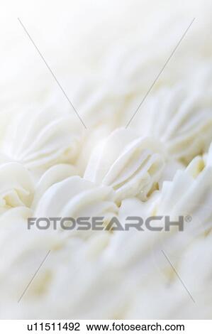 Stock Image - Close up of cream decorations, full frame. Fotosearch