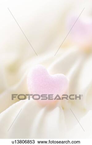 Stock Image - Close up of cream decorations, white background, soft focus. Fotosearch