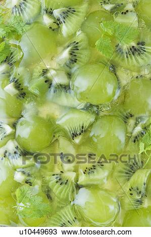 Stock Image - Close up of Muscat grape and kiwi tart, full frame. Fotosearch