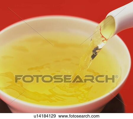 Stock Photo - Close up of tea being poured into a tea cup. Fotosearch
