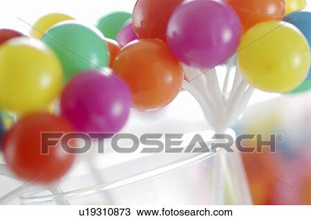 Stock Image - Colorful miniature balloons in a glass. Fotosearch