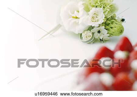 Stock Photograph - Flower bouquet and strawberry tart, white background. Fotosearch
