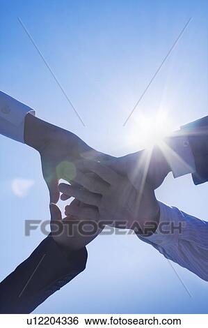 Four business people putting their hands together View Large Photo Image Stock Photograph - Four business people putting their hands together. Fotosearch