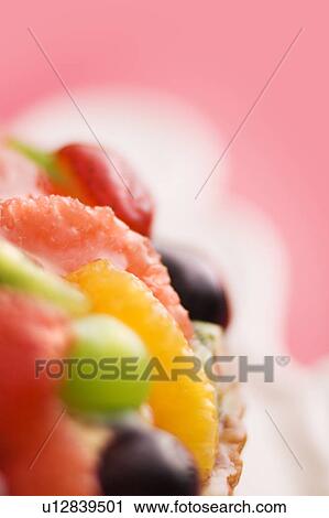 Stock Image - Fruit tart, close up, colored background. Fotosearch