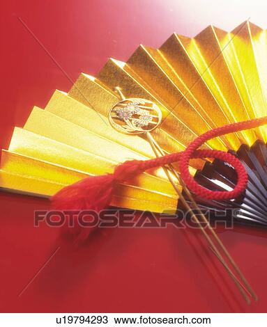 Stock Image - Gold fan and hair clip with floral pattern. Fotosearch