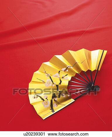 Stock Image - Gold fan decorated with cherry blossoms. Fotosearch