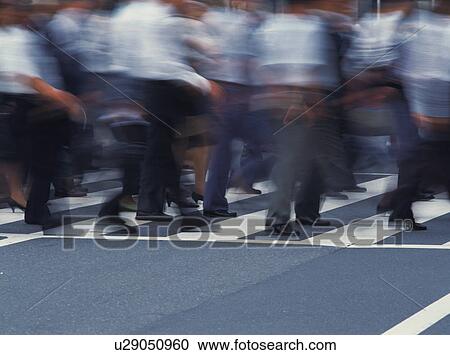 Stock Image - Group of people crossing at crosswalk. Fotosearch