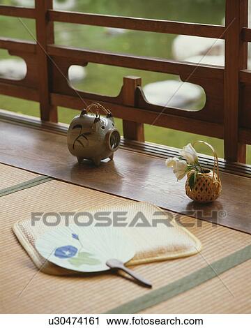 Stock Image - Japanese fan, pig-shaped insect repellent and flowers in a small woven basket. Fotosearch