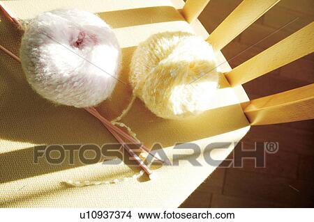 Picture - Knitting needles and balls of wool on chair. Fotosearch