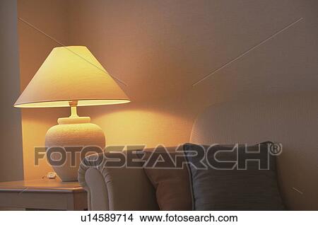 Picture - Lamp on a table next to a sofa. Fotosearch