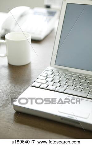 Laptop and mug on a desk View Large Photo Image Stock Photo - Laptop and mug on a desk. Fotosearch