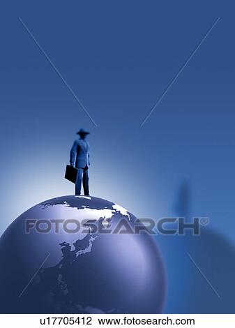 Stock Image - Man standing on globe. Fotosearch