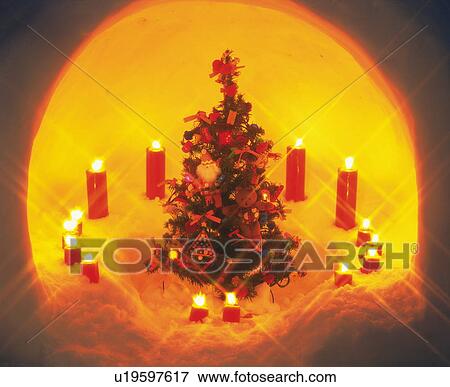 Miniature Christmas tree surrounded by lit candles View Large Photo Image Stock Photo - Miniature Christmas tree surrounded by lit candles. Fotosearch