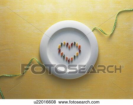 Stock Photo - Musical note shaped pasta arranged in a heart on a plate on a checked ribbon. Fotosearch