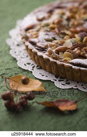 Nut tart and leaves, close up, green background View Large Photo Image Picture - Nut tart and leaves, close up, green background. Fotosearch