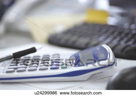 Stock Photograph - Office desk with pen, calculator and keyboard. Fotosearch